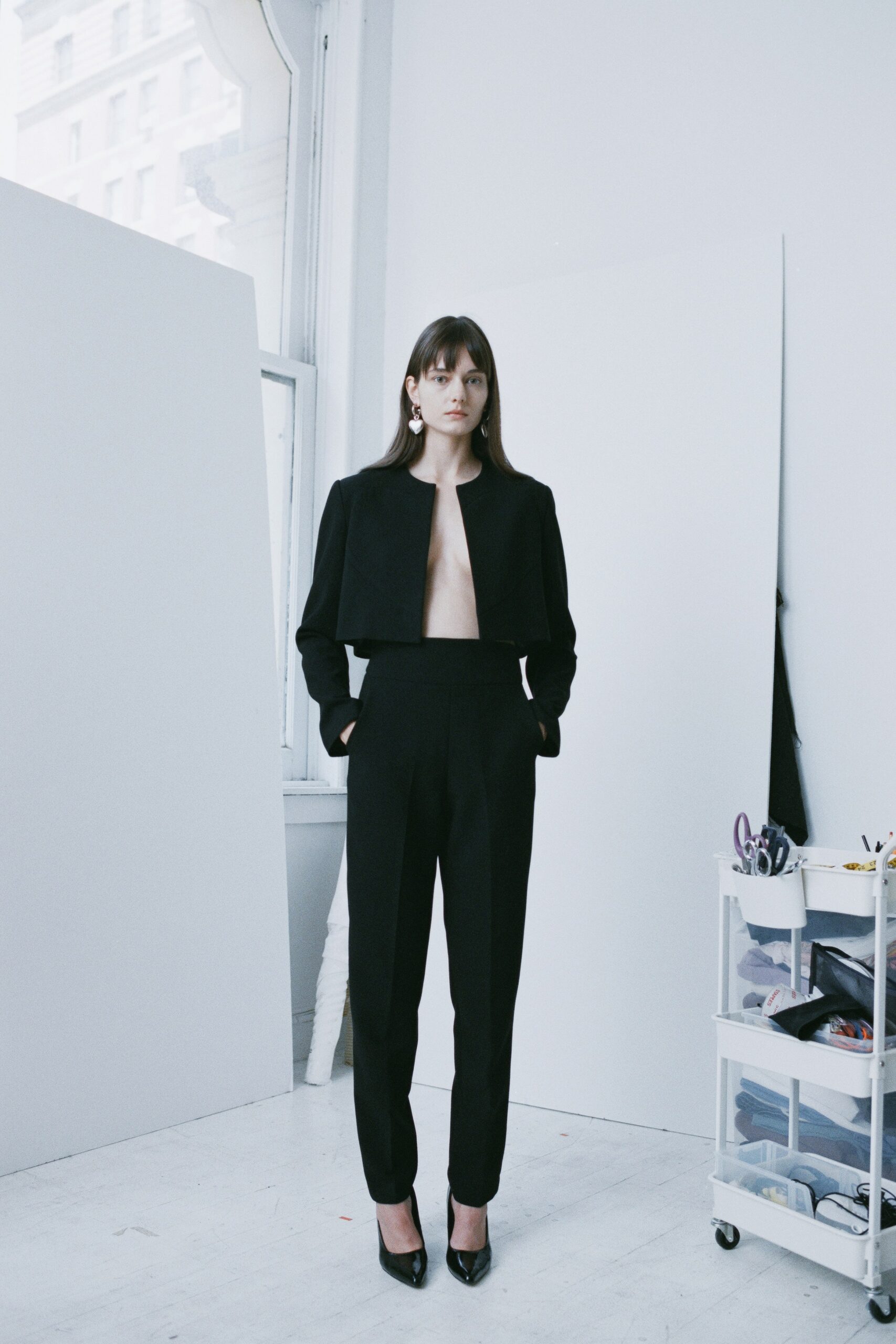 A fitted black wool jacket with a structured design paired with matching pants.