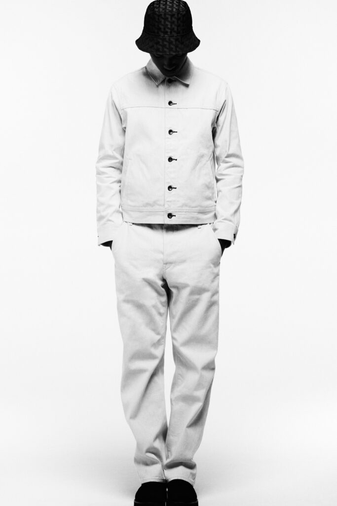 A relaxed white cotton jacket with long sleeves and collared design, paired with matching pants.