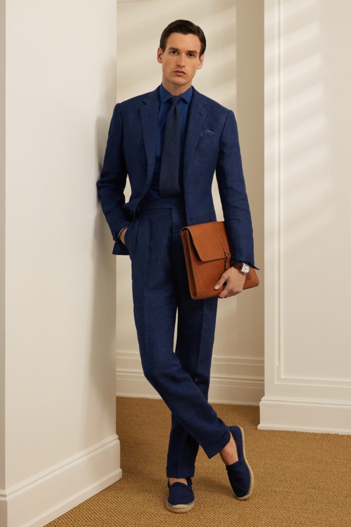 A tailored blue cotton suit with long sleeves and a collared shirt, featuring straight-leg trousers.