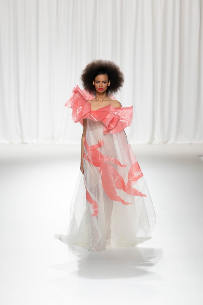 A relaxed pink sheer off-shoulder dress with layered ruffles and a flowing silhouette.