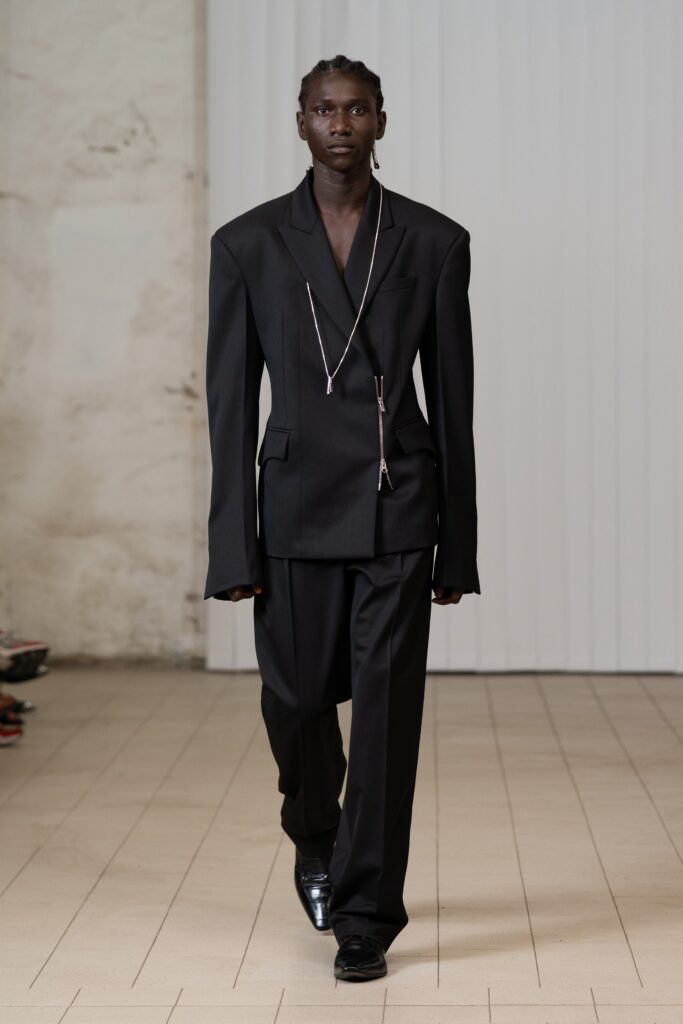 An oversized black tailored suit featuring a unique silhouette and sleek design elements.