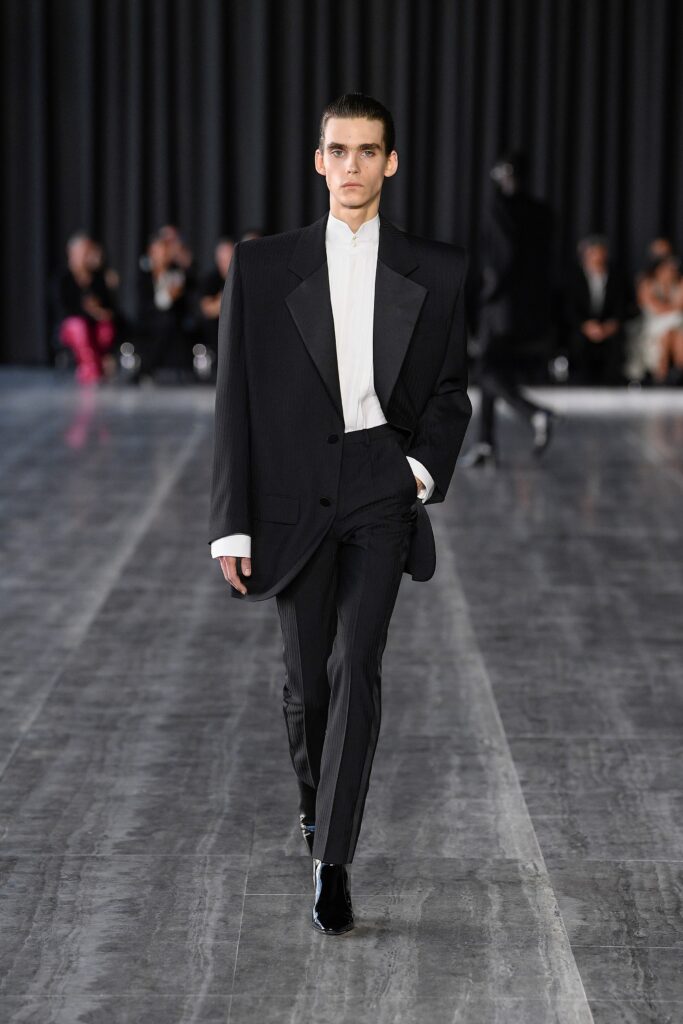 A tailored black wool suit with a long-sleeve collared shirt, exuding sophistication.