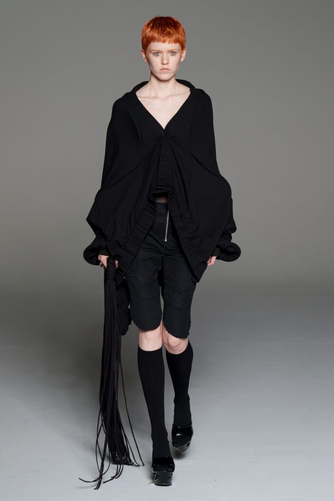 black oversized poncho with fitted shorts