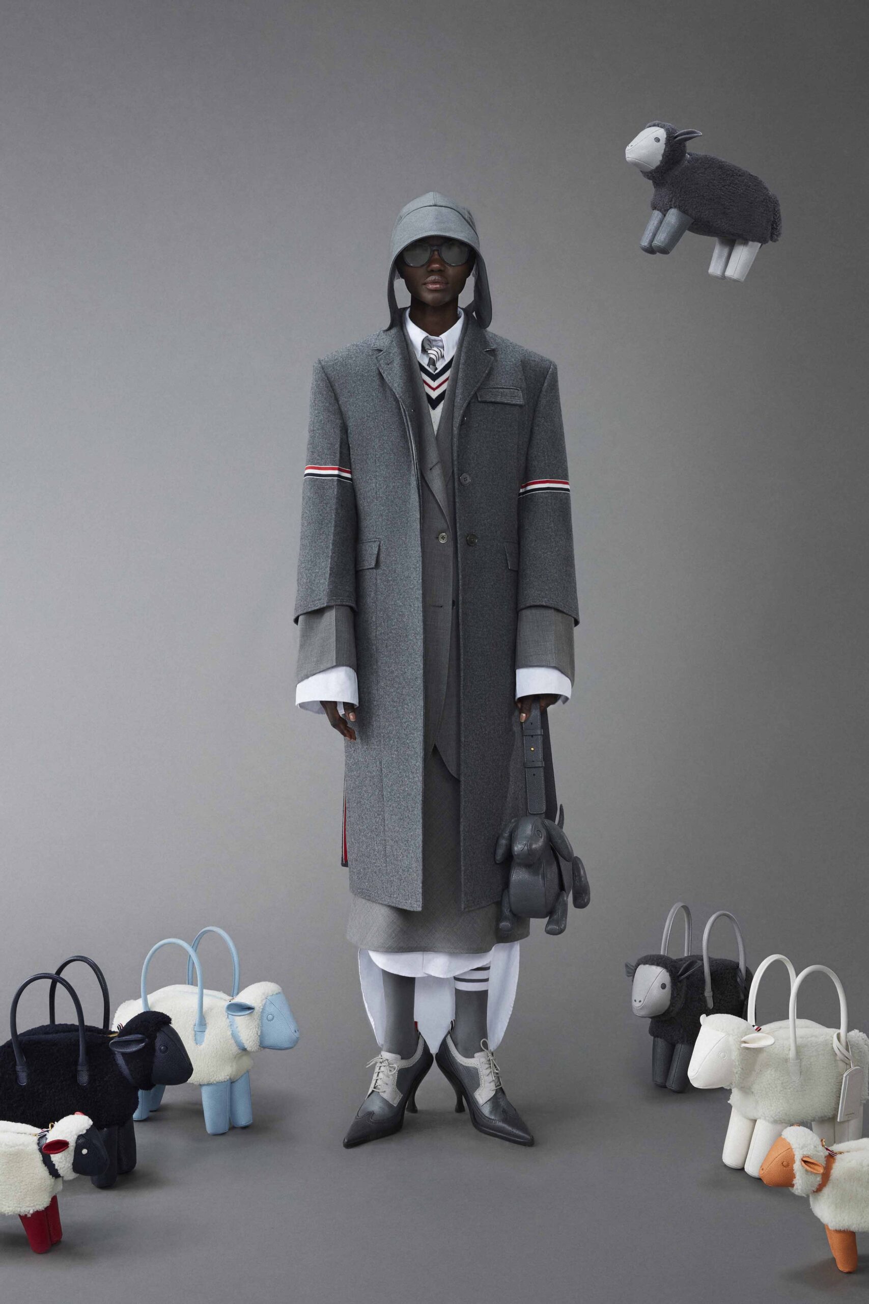 A relaxed gray wool coat with long sleeves and a collared design, featuring buttoned details.
