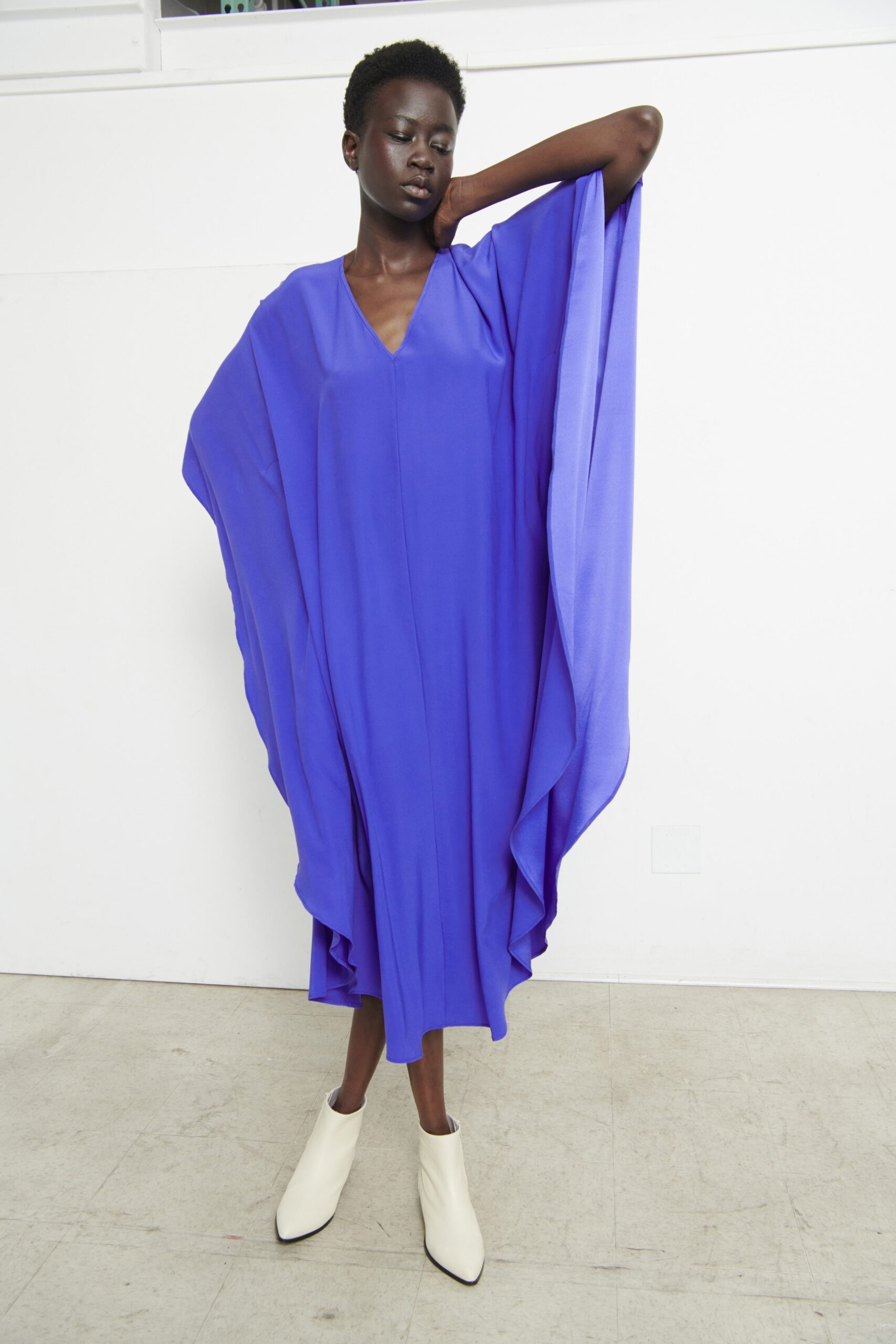 A relaxed purple silk sleeveless dress with a V-neckline and asymmetric design.