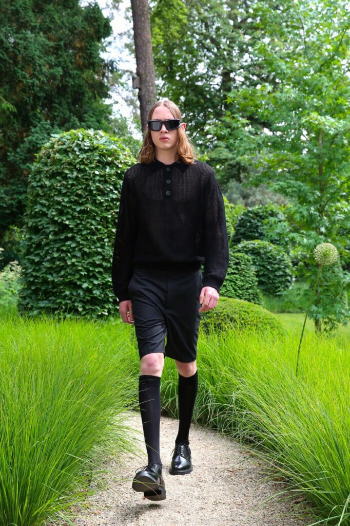 A fitted black cotton long-sleeve collared top paired with black shorts, featuring button details.