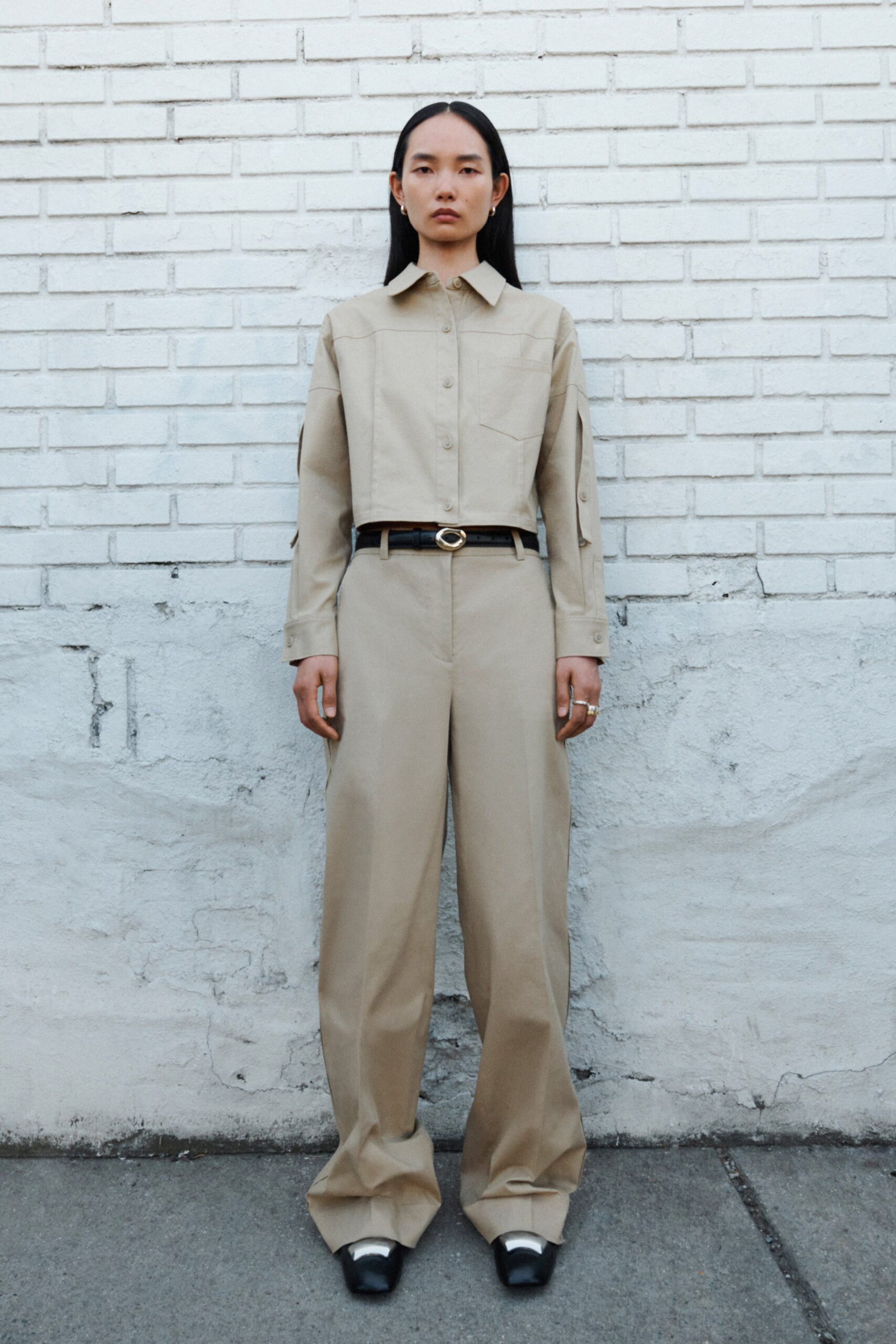 A relaxed beige cotton long-sleeve shirt paired with wide-leg pants.