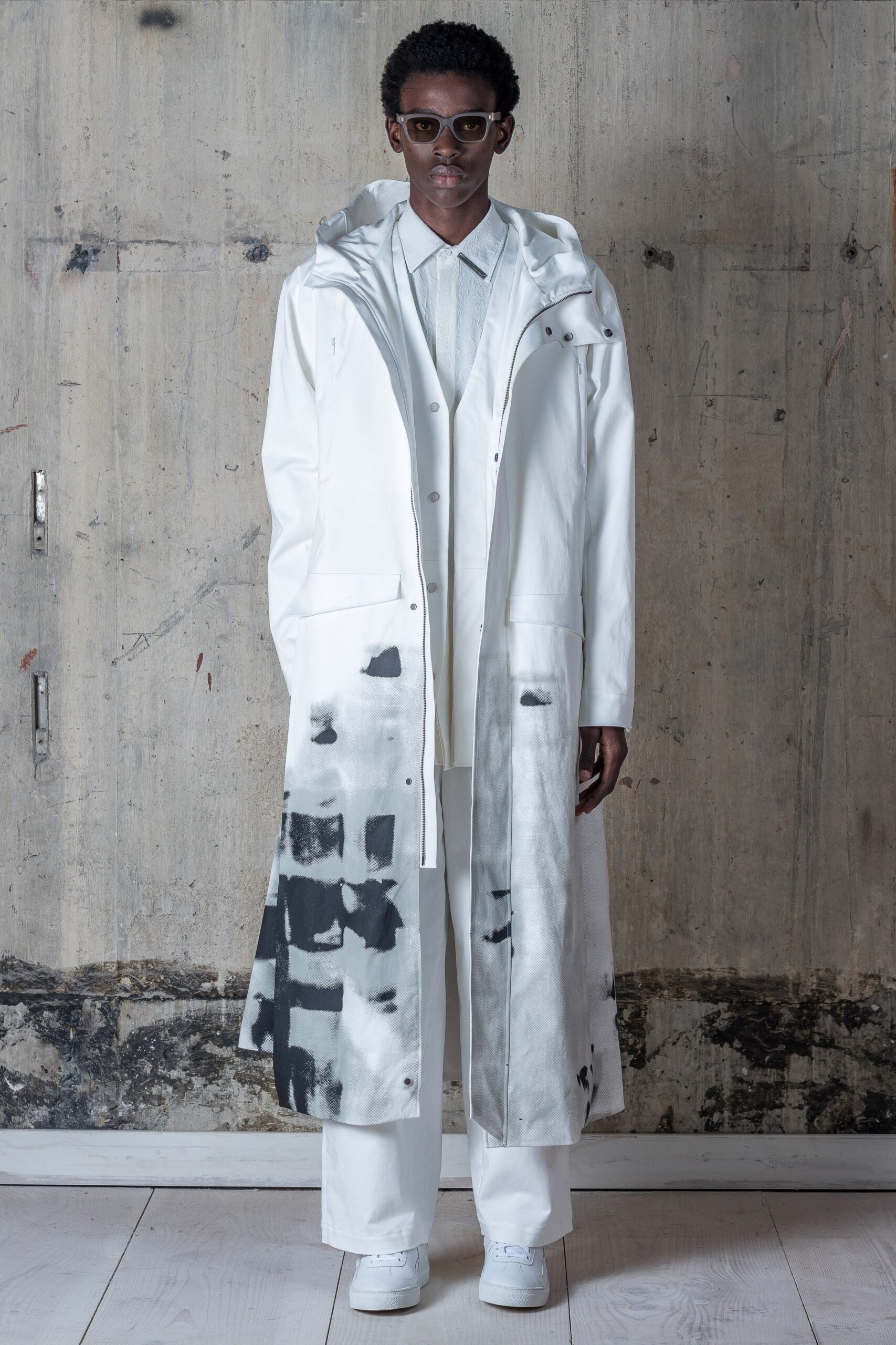 A relaxed white coat with a printed design, paired with matching relaxed pants.