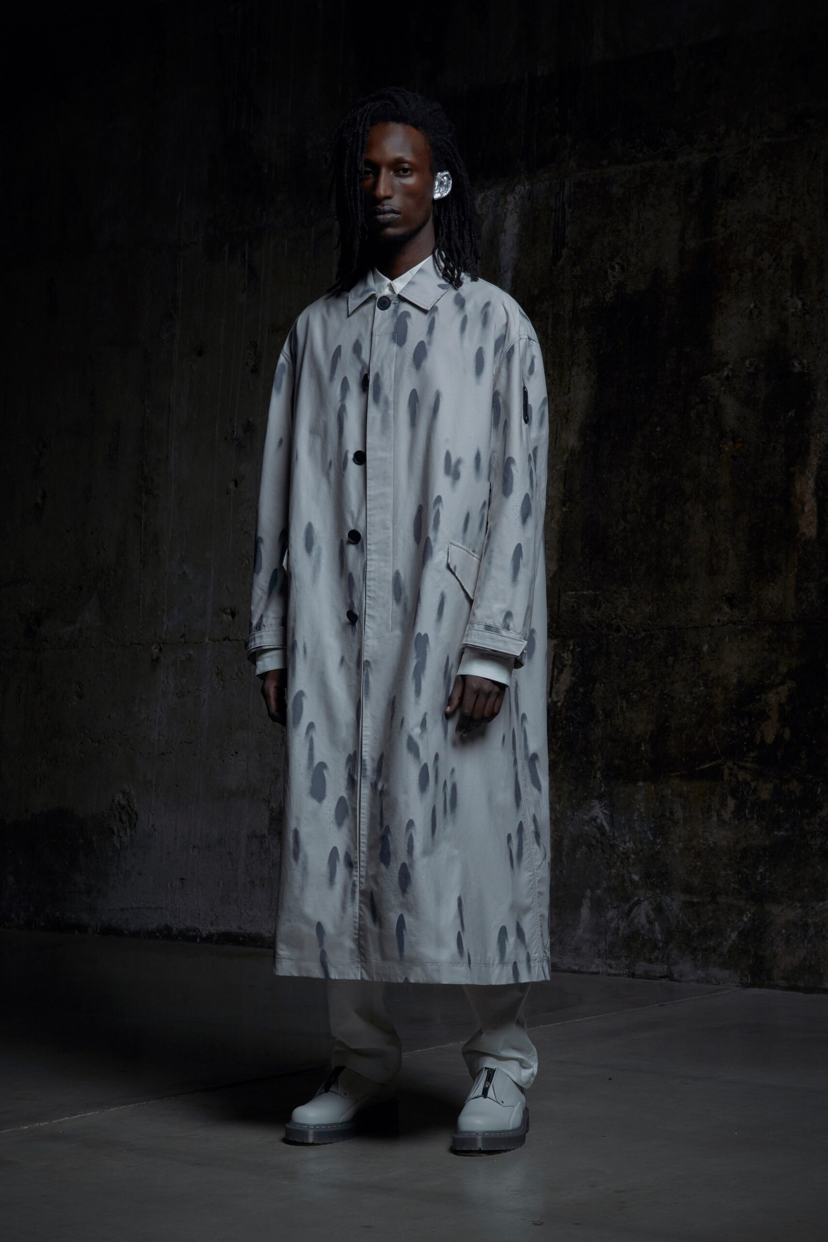 A relaxed gray coat with a collared neckline and long sleeves featuring a unique print.
