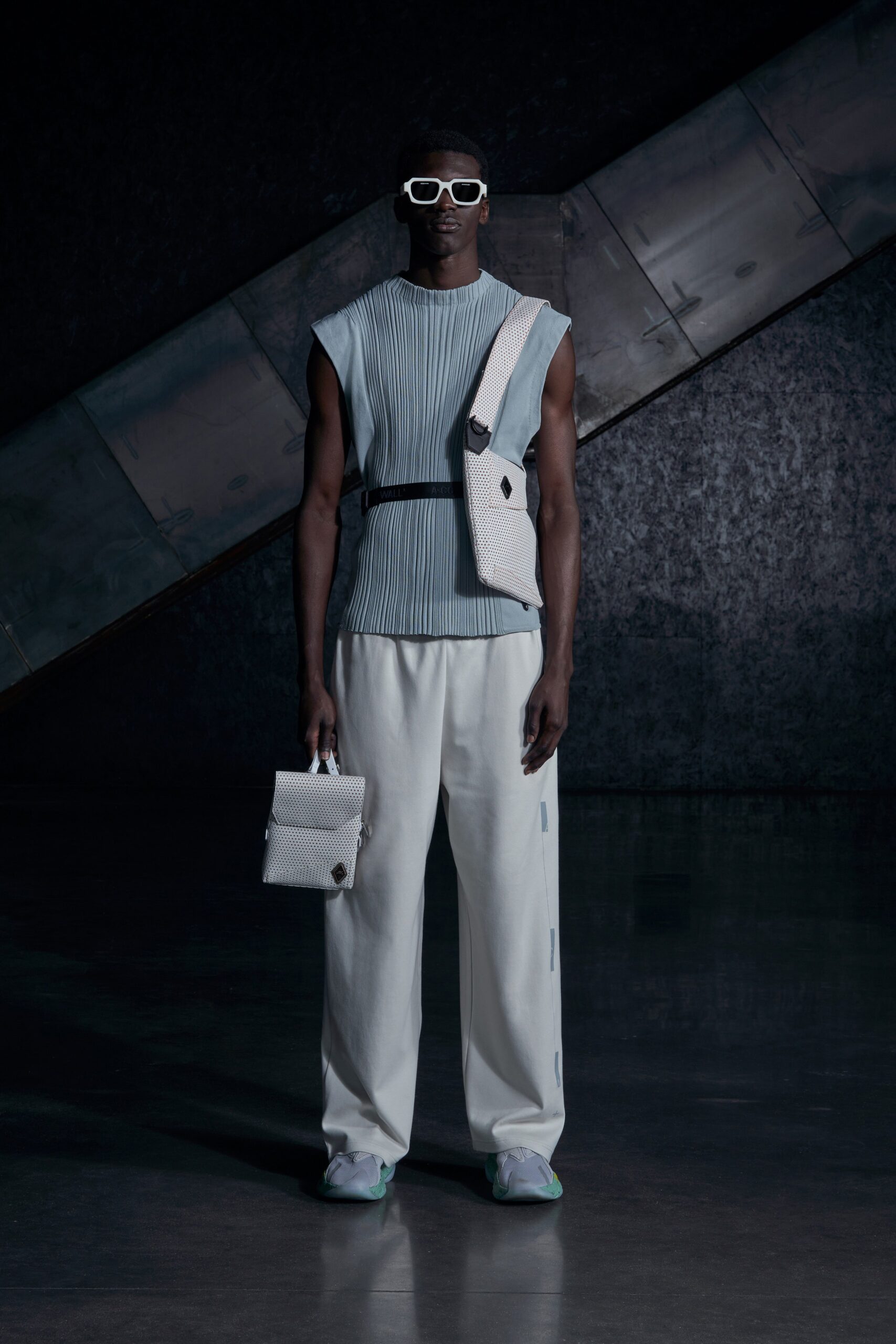 A relaxed blue pleated sleeveless top paired with wide-leg white pants.