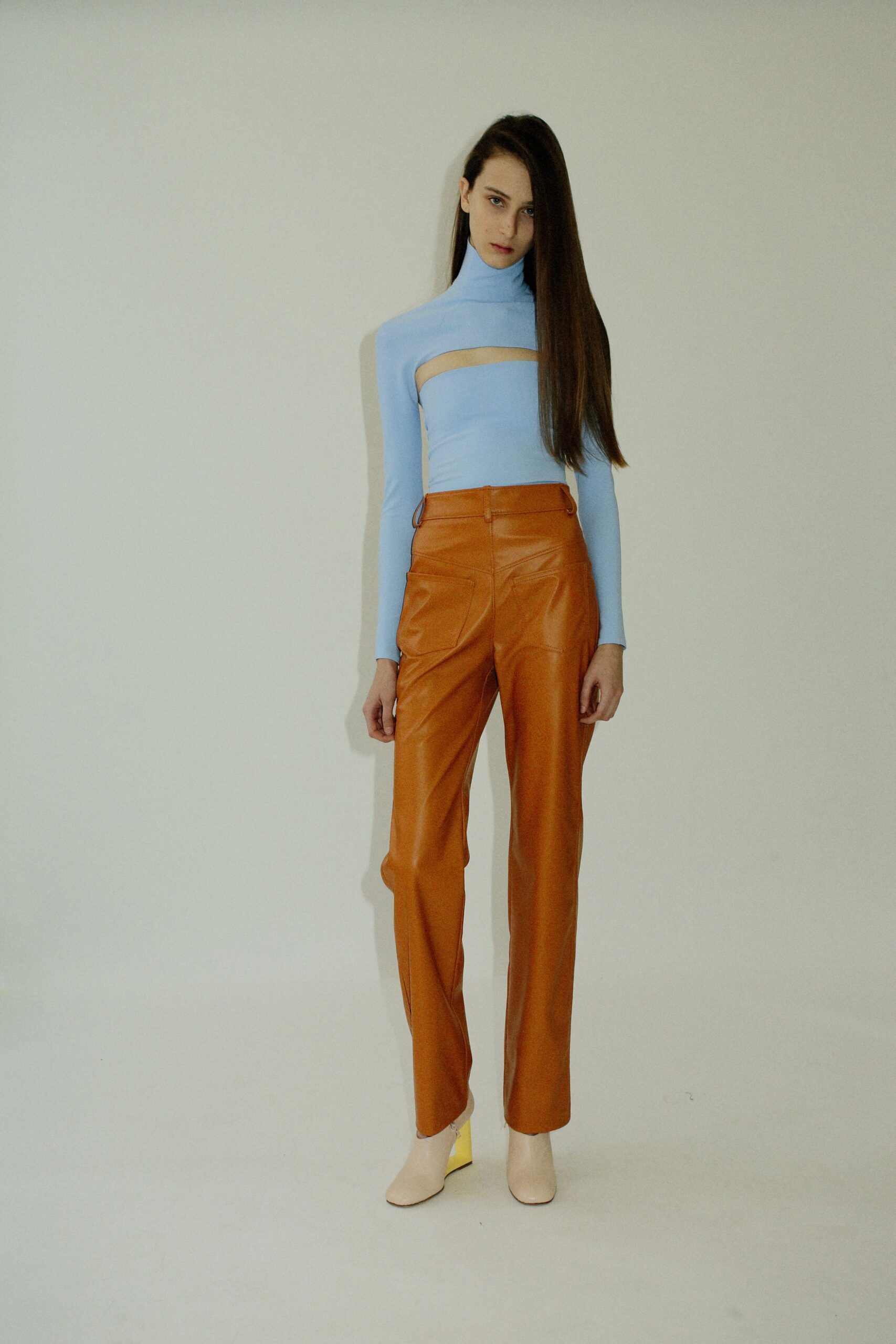 fitted blue top with cutout and orange leather pants