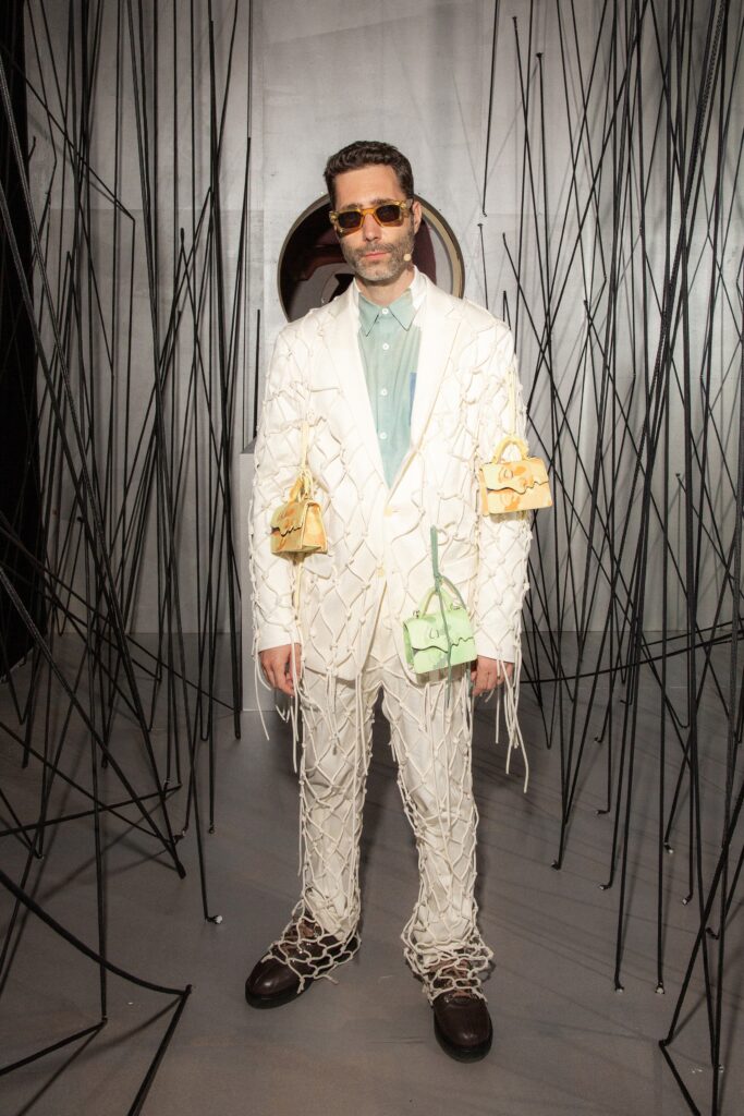 A fitted white cotton suit with long sleeves and a collared shirt, featuring a layered design.