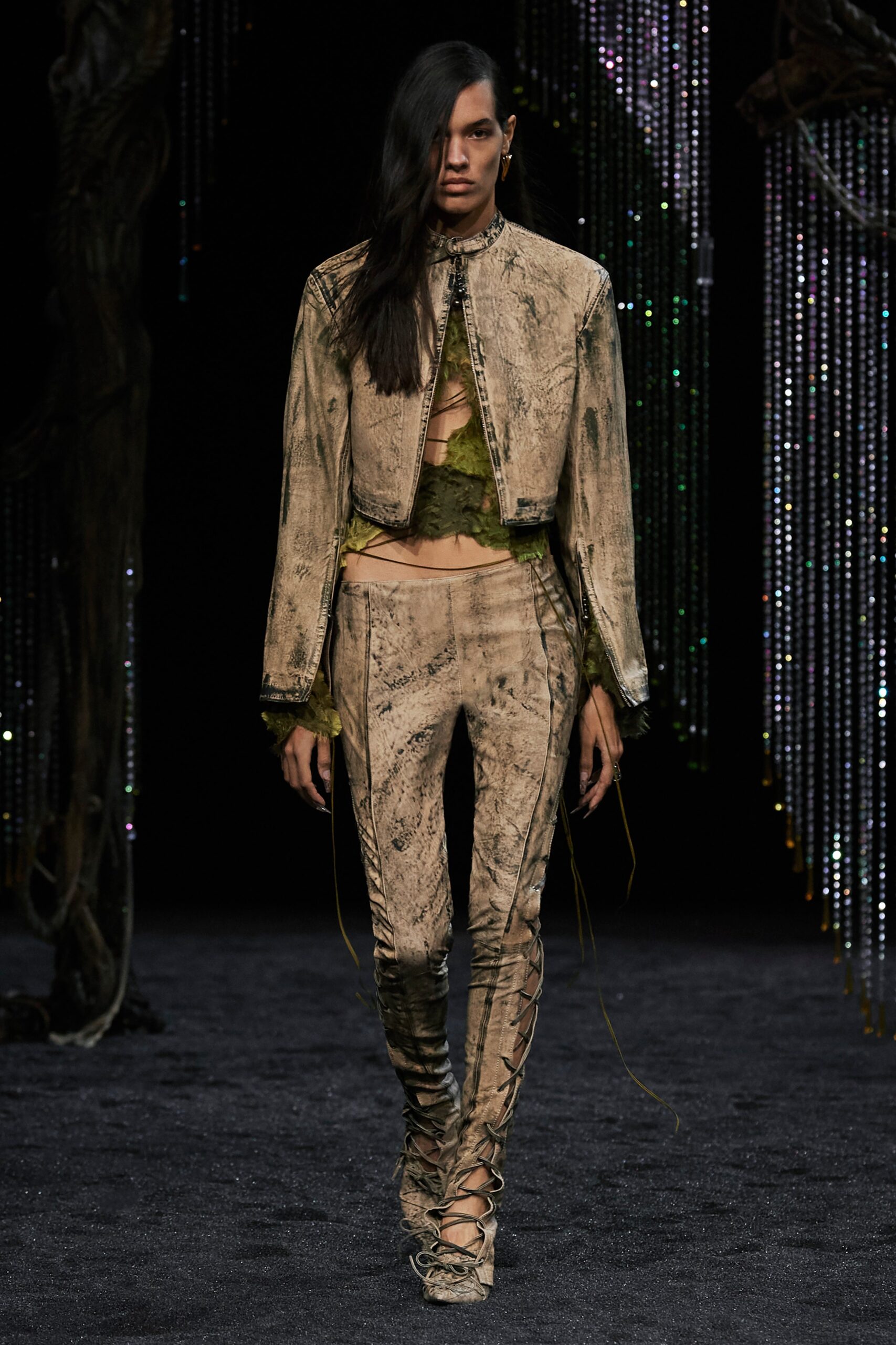 A fitted beige leather jacket with long sleeves and asymmetric pants, featuring a unique zippered design.