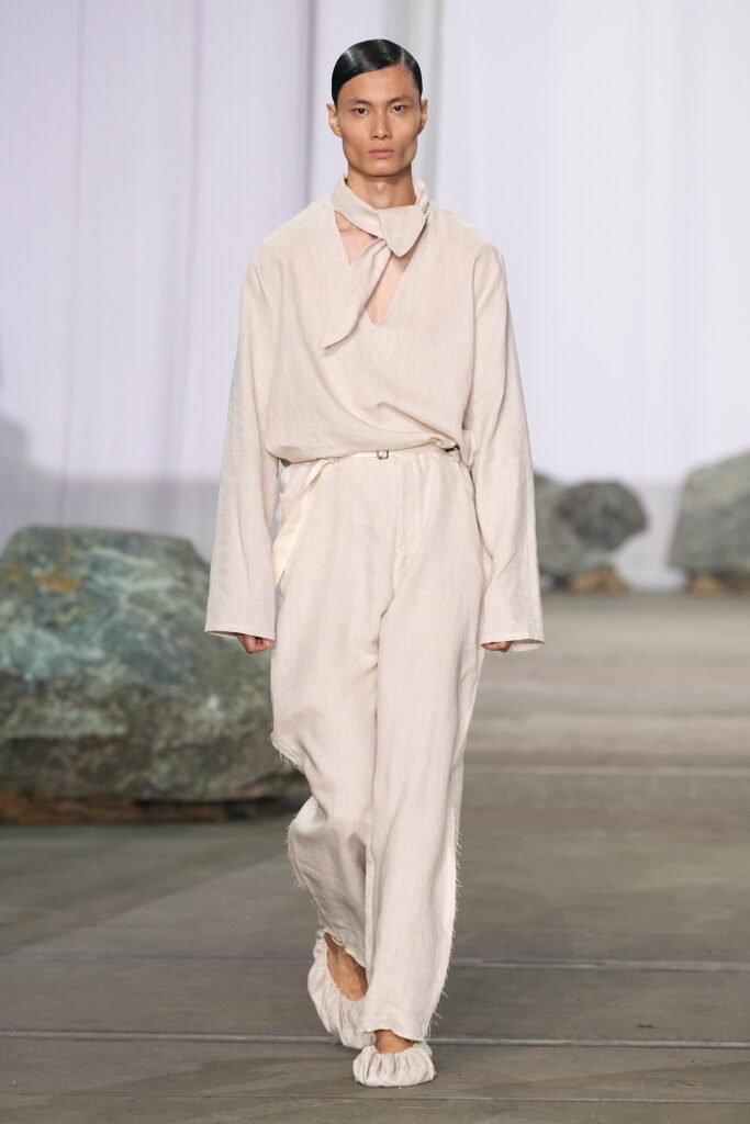 A relaxed beige cotton shirt with long sleeves and asymmetric design paired with matching pants.