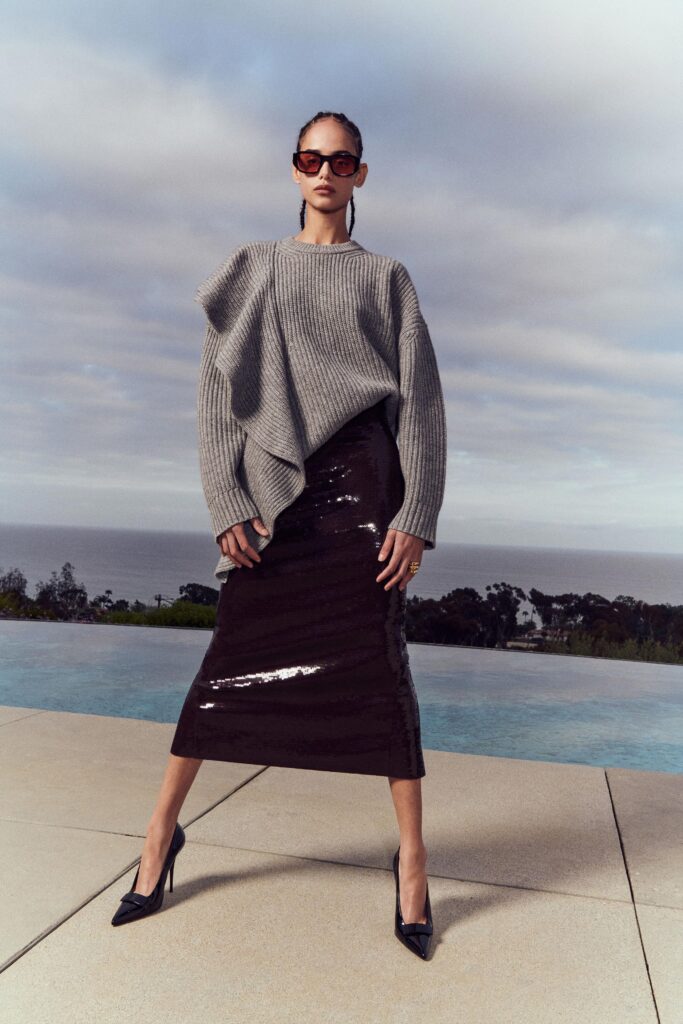 A relaxed gray wool long-sleeve top paired with a fitted black sequin pencil skirt.