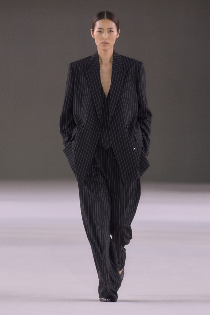 A tailored black striped suit with a V-neckline and long sleeves, exuding sophistication.