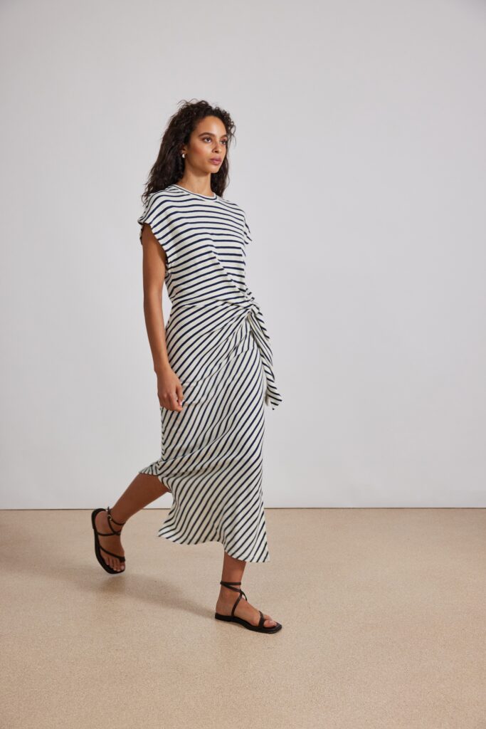 A relaxed white and black striped dress with short sleeves and a V-neckline.