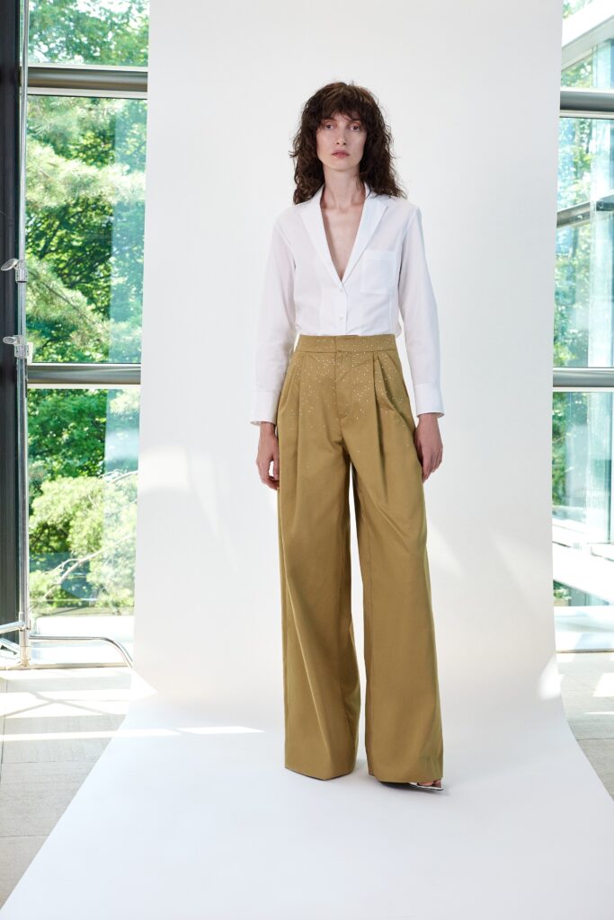 A fitted white collared shirt paired with pleated wide-leg beige pants.