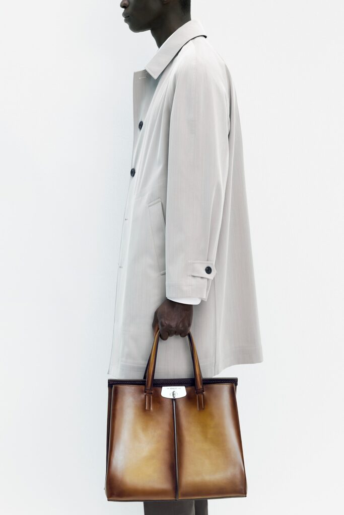 A relaxed beige cotton coat with long sleeves and a collared design, featuring button details.