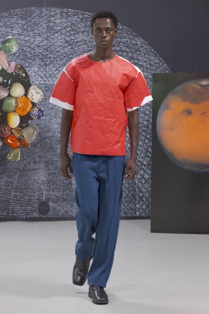 A relaxed red cotton top with short sleeves paired with blue pants featuring an asymmetric design.