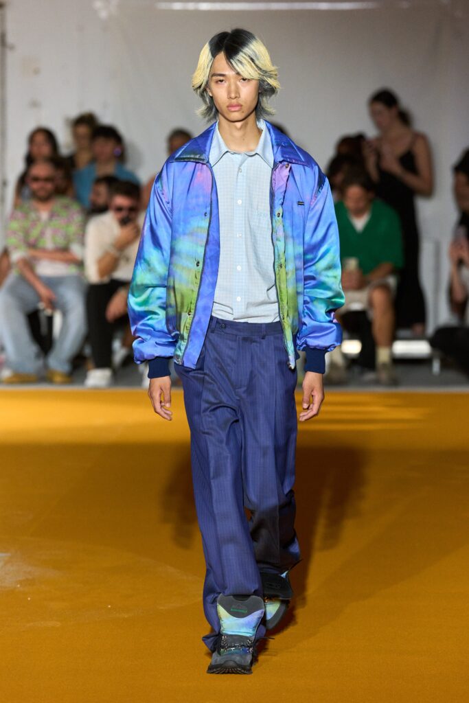 A relaxed multicolor jacket with long sleeves and collared design paired with striped pants.