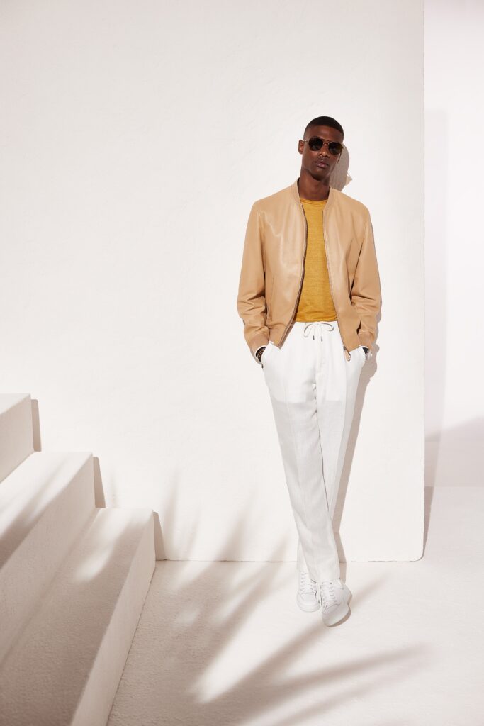 A relaxed beige leather jacket paired with white cotton pants for a stylish look.