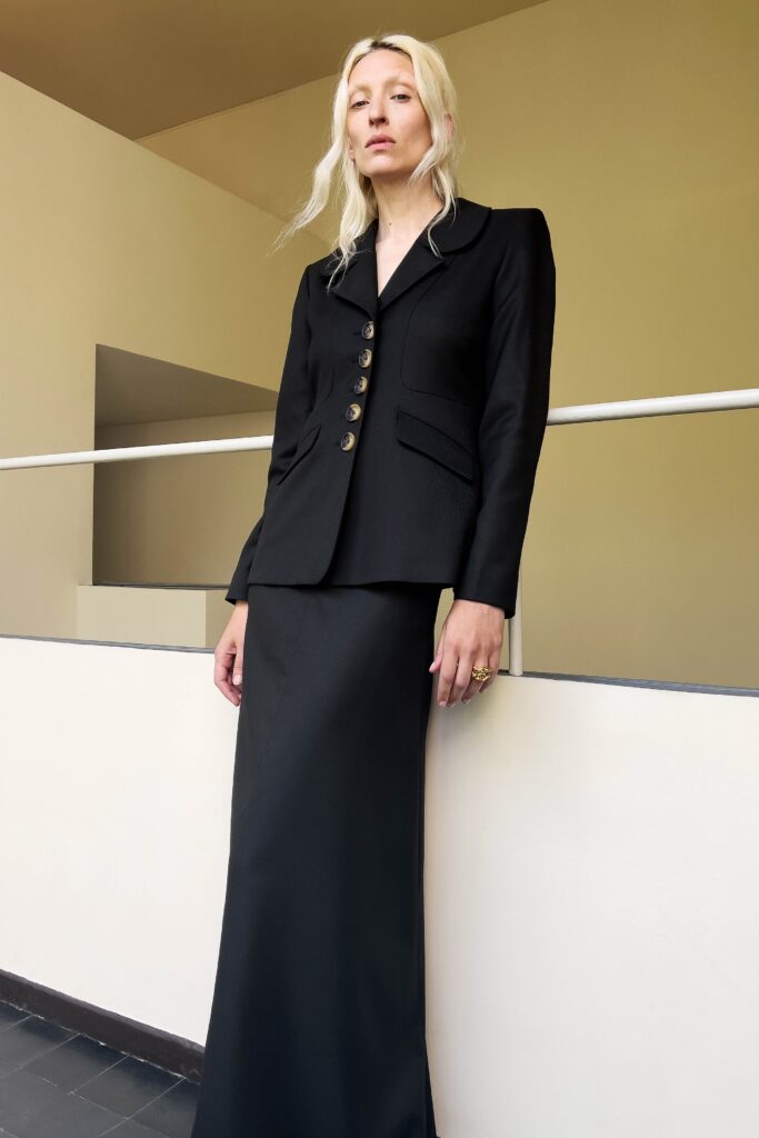 A fitted black blazer dress with long sleeves and a collared neckline.