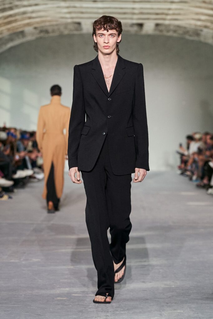 A tailored black suit with a collared long-sleeve jacket and straight-leg trousers.
