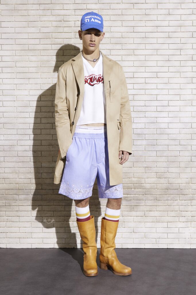 An oversized beige coat paired with blue cotton shorts and knee-high boots for a trendy look.