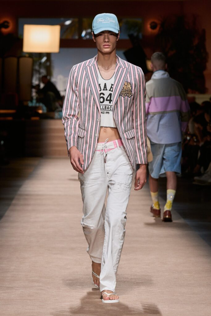 A fitted pink striped blazer paired with white pants, featuring a collared design.