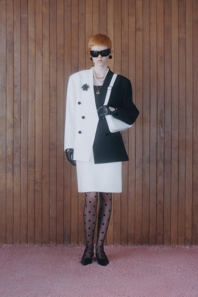 A fitted black and white blazer paired with a polka-dot skirt, showcasing a stylish contrast.