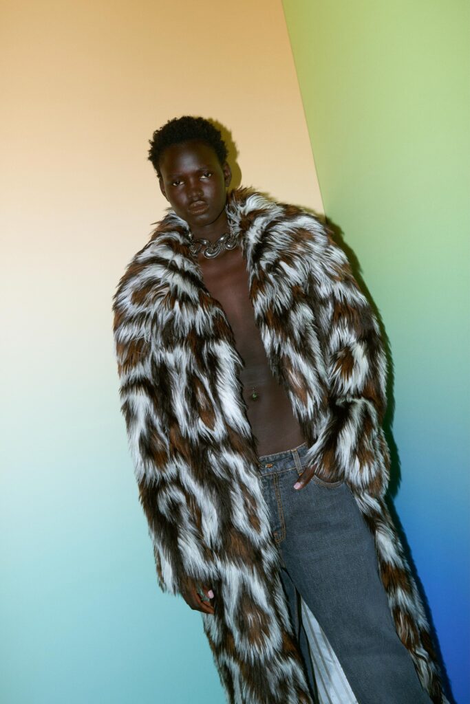 A relaxed brown striped fur coat paired with denim pants, creating a bold fashion statement.