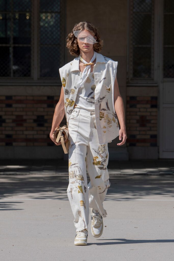 A relaxed white sleeveless top with a collar paired with printed pants.