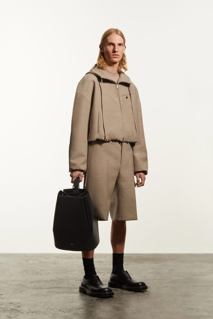 A relaxed beige jacket with long sleeves and shorts, featuring a zippered detail.