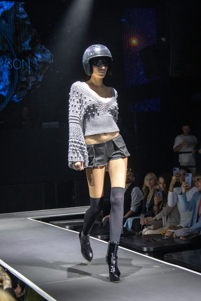 A fitted gray knit long-sleeve top paired with black leather shorts, featuring a layered design.
