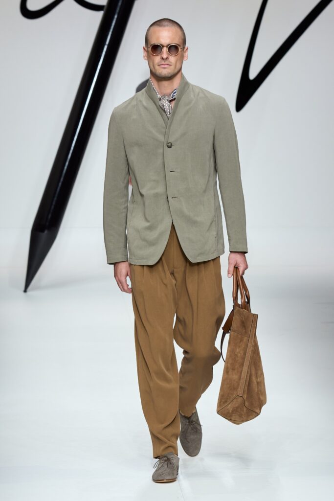 A relaxed beige cotton jacket with a collared design paired with brown wide-leg pants.