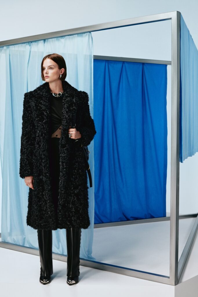 A fitted black fur coat paired with sleek leather pants, featuring a collared design.