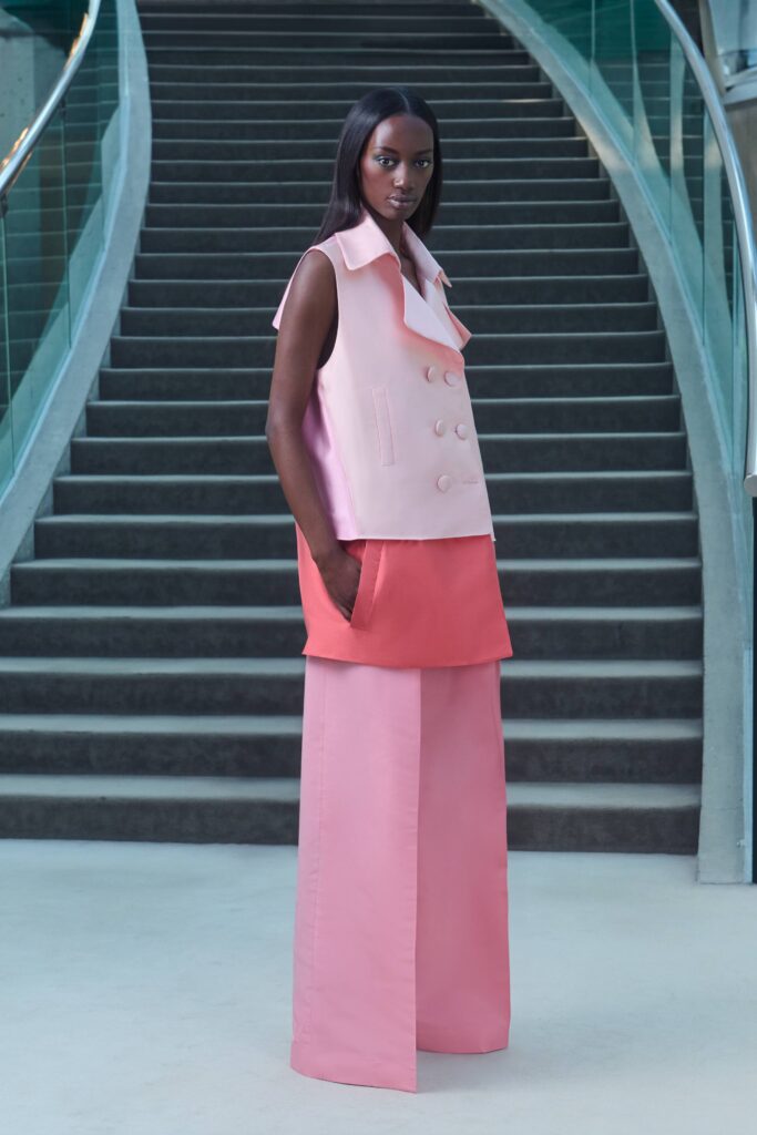 A relaxed pink sleeveless vest with a collared design paired with wide-leg pants.