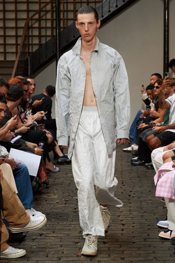 A relaxed fit gray striped shirt paired with white straight-leg pants.