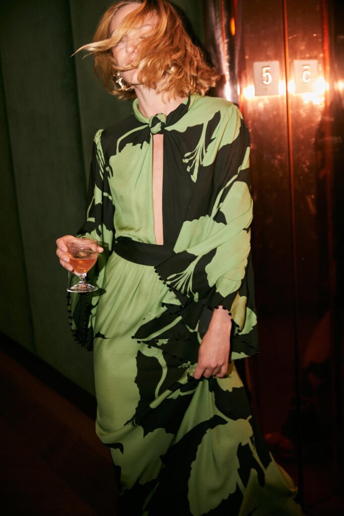 A relaxed green and black printed dress with long sleeves and a V-neckline.