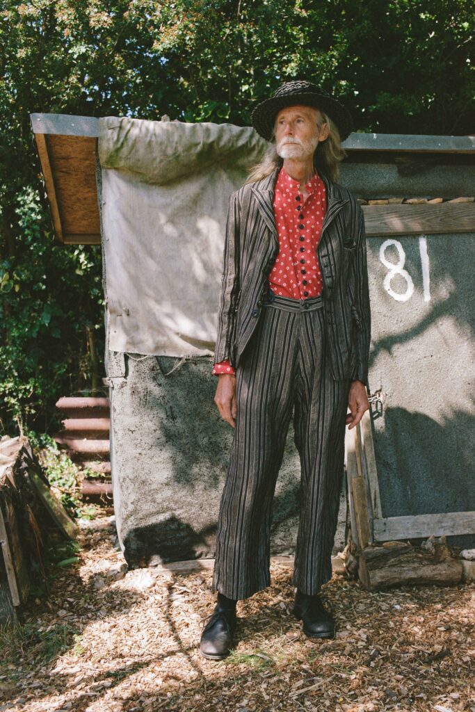 A tailored black and red striped suit with a collared long-sleeve shirt.