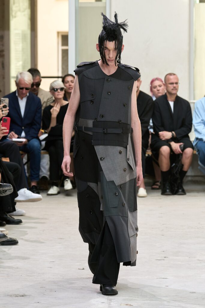 A relaxed sleeveless dress in black and gray with an asymmetric design and collared detail.