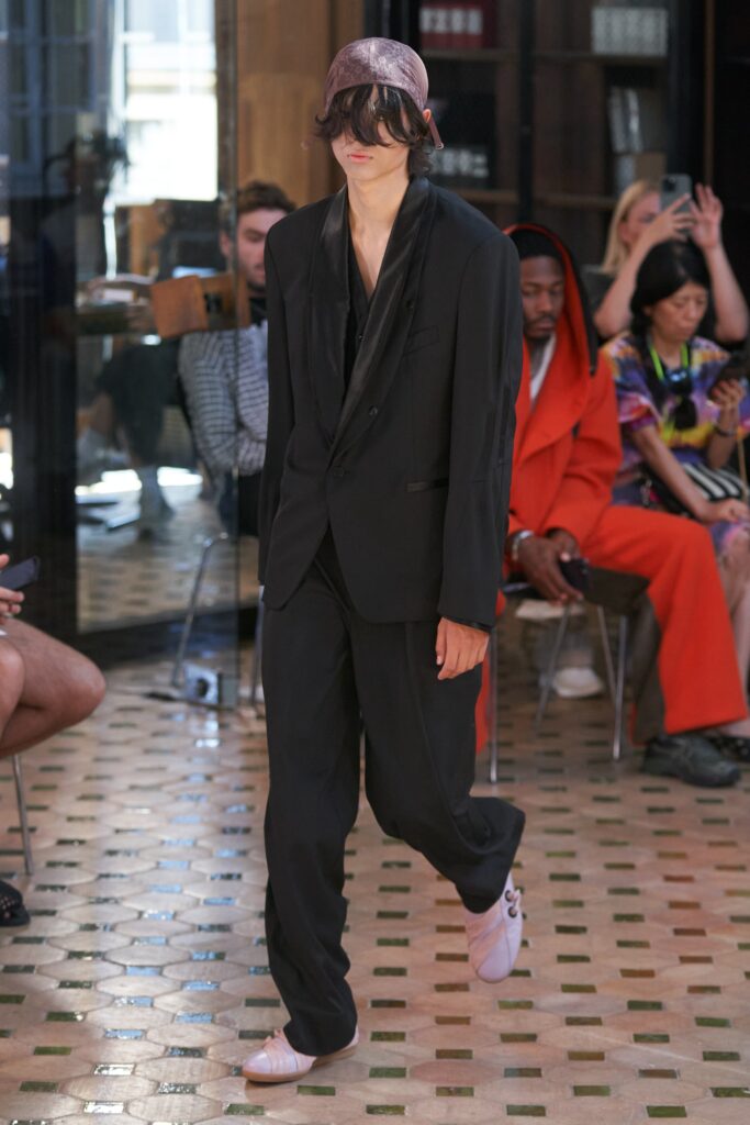 A relaxed black cotton suit with long sleeves and a collared design featuring straight-leg trousers.