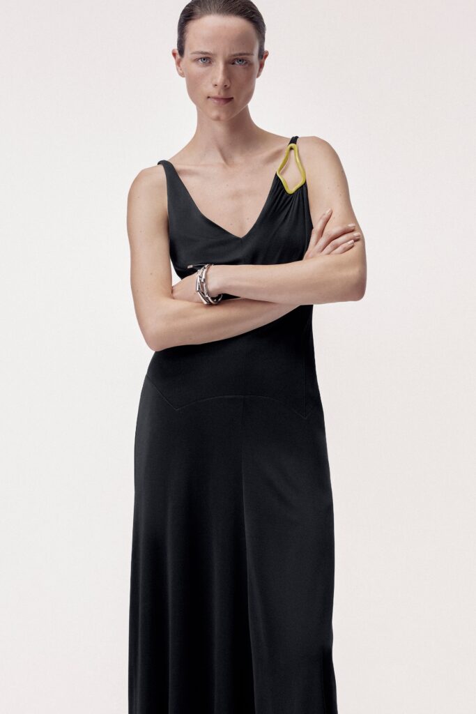 A fitted black silk dress with a sleeveless design and V-neckline.