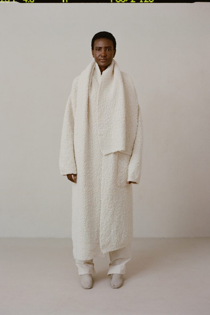 An oversized white wool coat with long sleeves and a layered design.