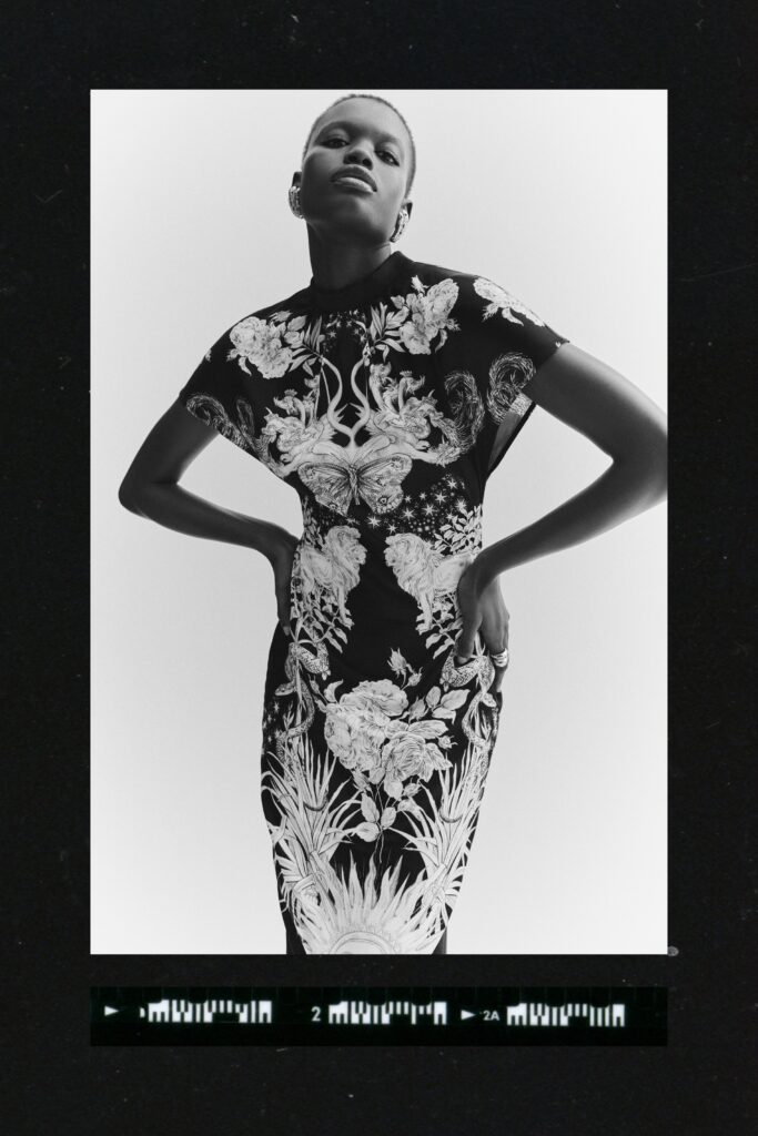 A fitted black and white floral dress with a high neckline and short sleeves.