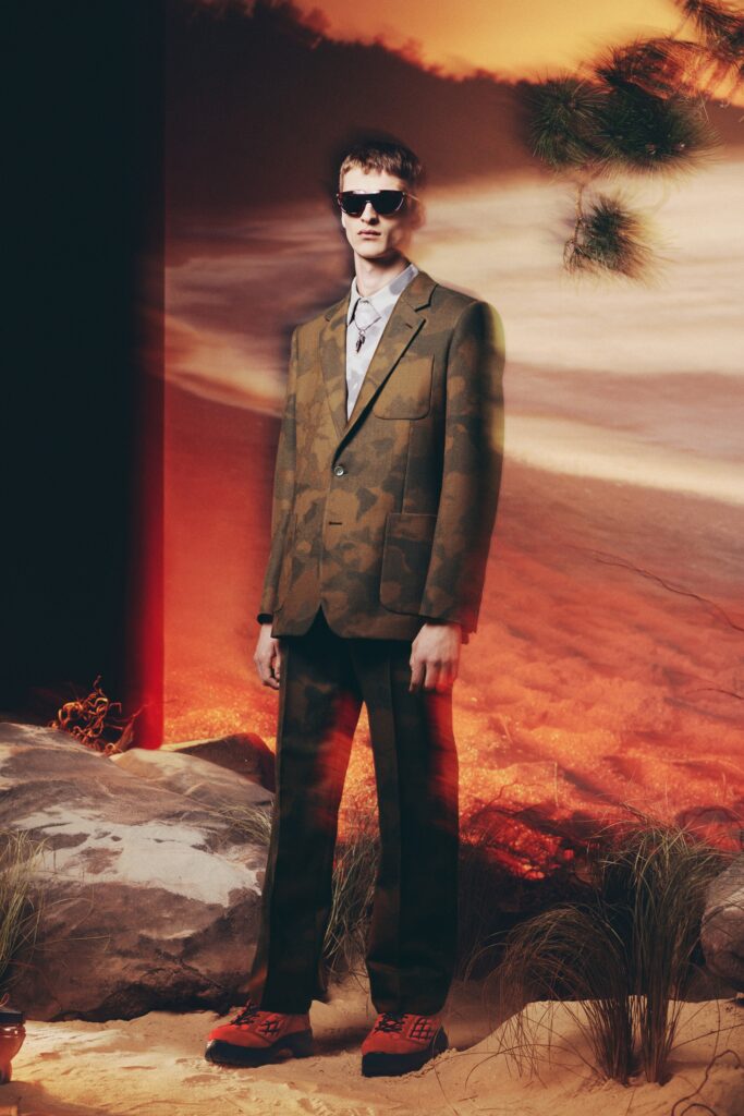 A tailored green suit with a long-sleeve collared shirt featuring a printed design.
