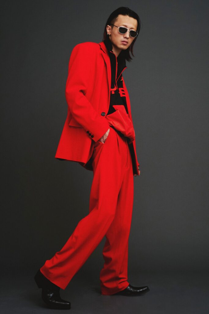 A fitted red cotton suit with long sleeves and a collared design featuring straight-leg trousers.
