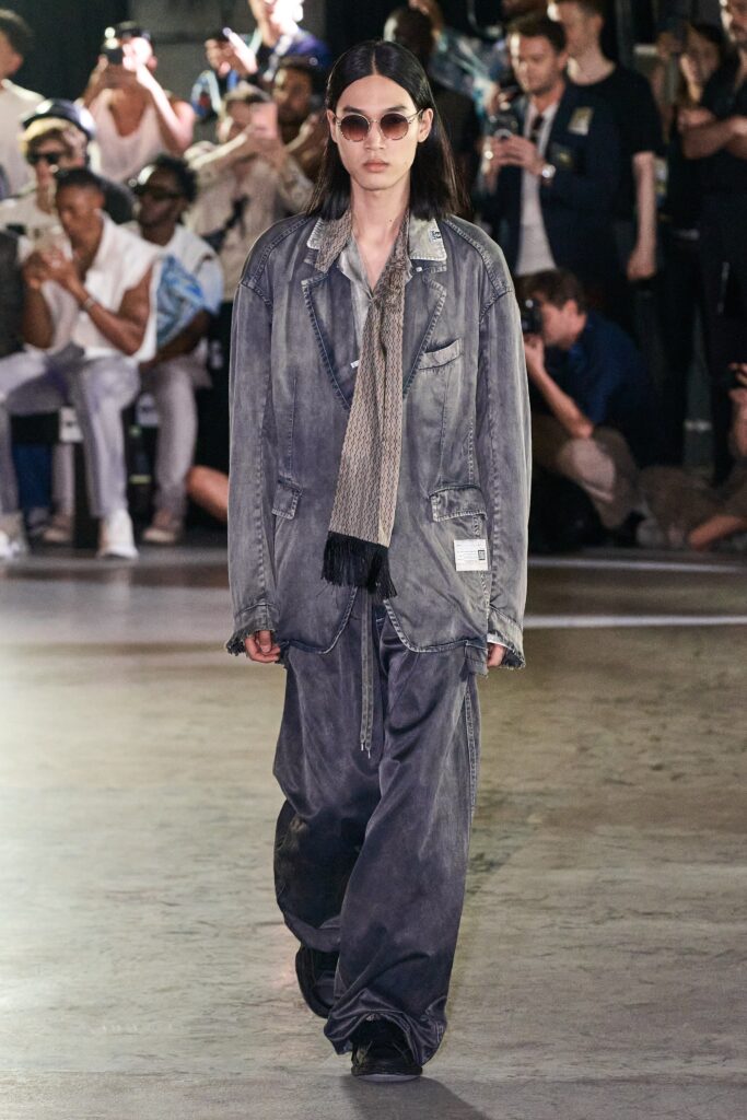 An oversized gray denim jacket with long sleeves and collared design, paired with matching pants.