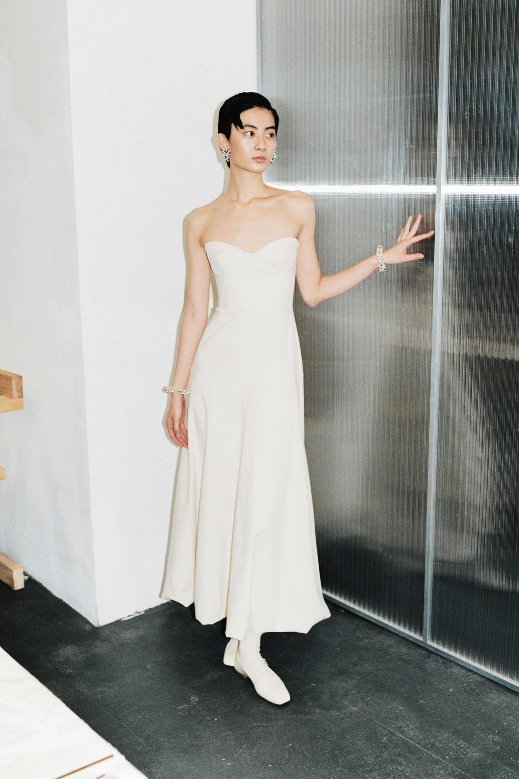 A fitted cream silk strapless dress with a V-neckline and A-line silhouette.